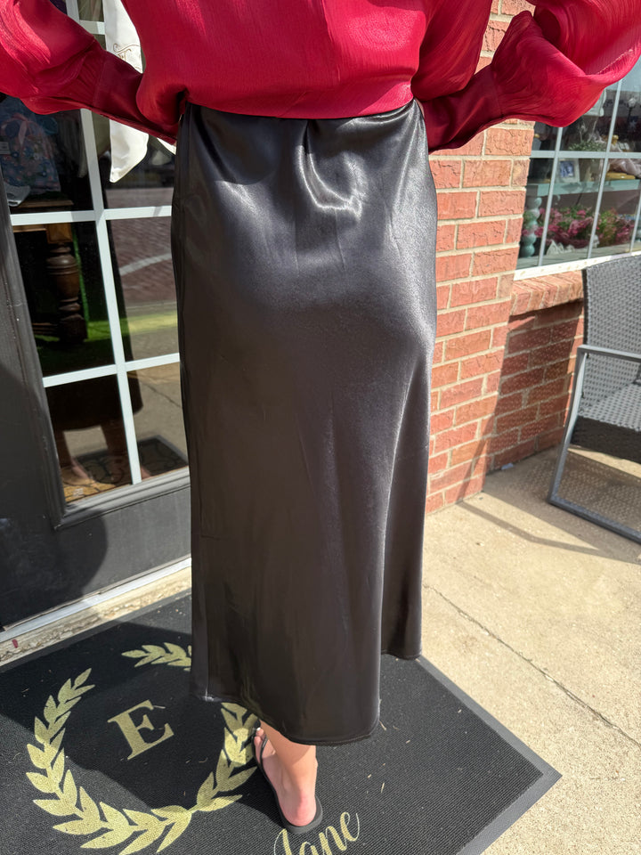 Glitter Midi Skirt: shiny black satin with elastic waist; available in sizes XS to XL.
