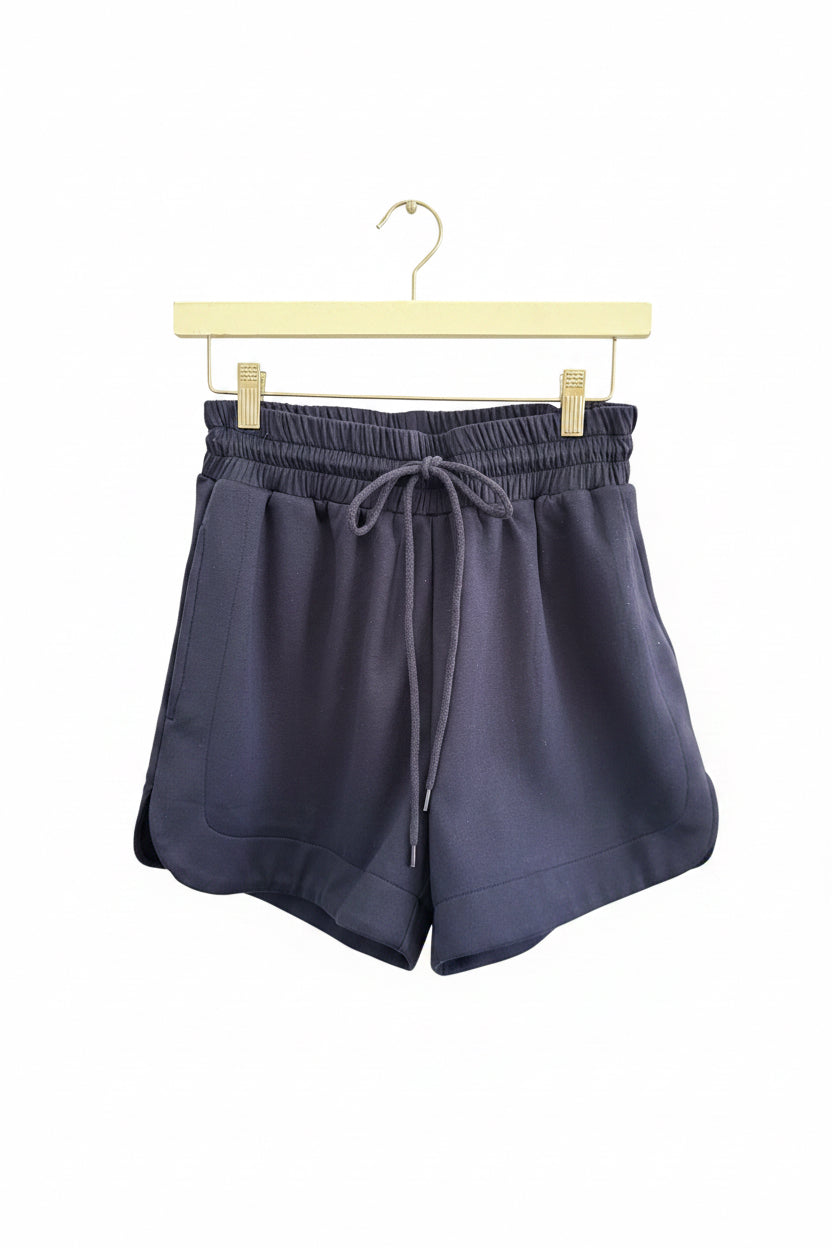 Buttery Soft Shorts in navy blue lightweight fabric with an elastic waistband and side pockets; available in sizes S-XL.