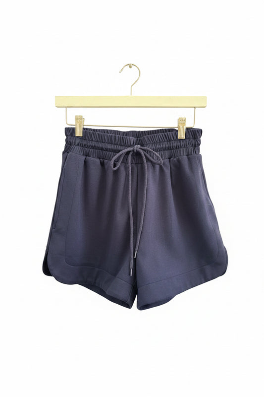 Buttery Soft Shorts in navy blue lightweight fabric with an elastic waistband and side pockets; available in sizes S-XL.