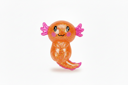 The Cute Axolotl Squeeze Toy has a glittery orange body, big black eyes, pink cheeks, a cheerful smile, and bright pink feathery gills. Available in multiple sizes.