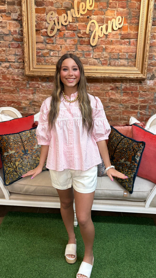 Gathered Piping Striped Blouse in pink; available in sizes XS–XL. Features piping, gathered detail, and vertical stripes.