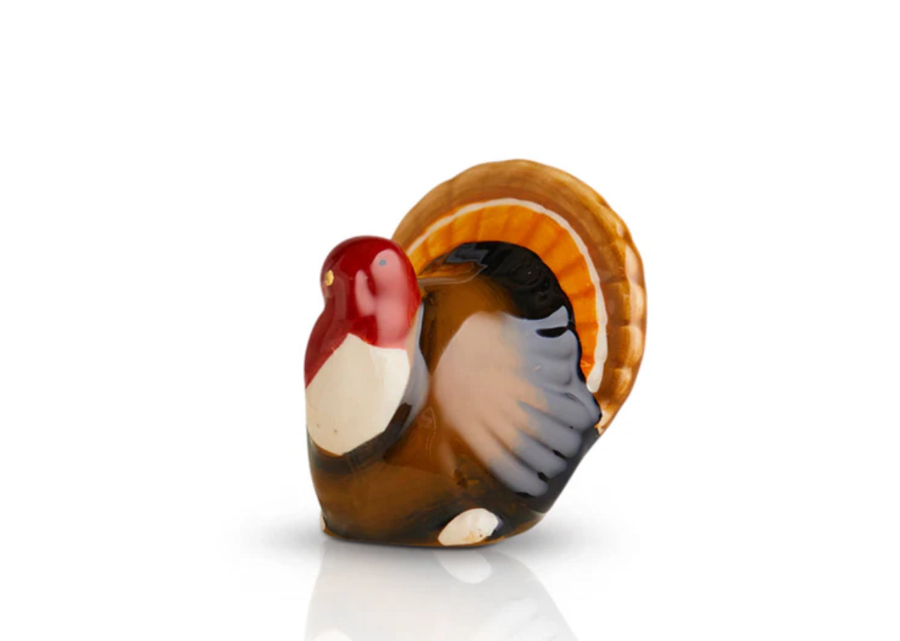 Small, colorful glass turkey figurine from Nora Fleming Minis collection. Red head, white and brown body, orange and yellow tail feathers. Intricately detailed. Sizes available: Mini.