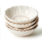 Four cream ceramic Sunflower Bowls with petal rims, textured centers, dishwasher safe. Available in small and large sizes.