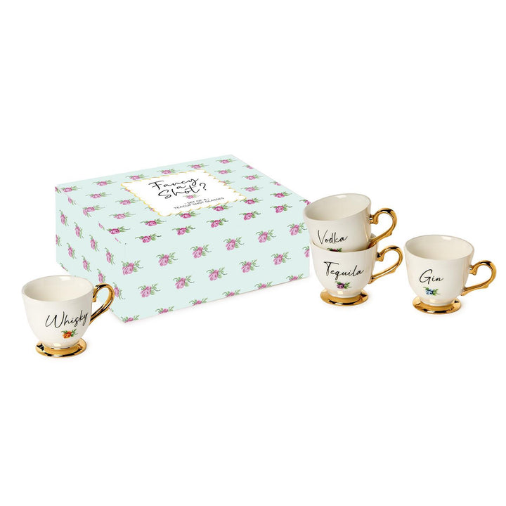 Set of four cream porcelain shot glasses with gold handles, labeled Whisky, Vodka, Tequila, Gin. Includes floral gift box.