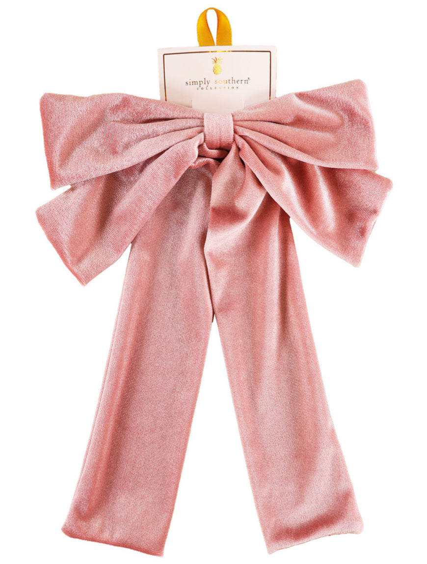 Large pink velvet bow hair accessory with long tails, yellow hanging loop, available in one size, Simply Southern label.