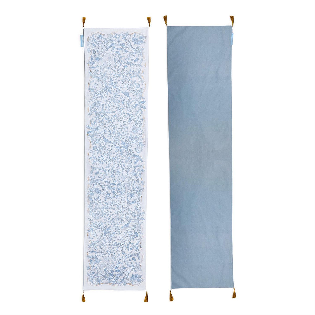 Gilded Cottage Double-Sided Table Runner with blue and white floral bird pattern, solid light blue reverse, and corner tassels. Available in multiple sizes.