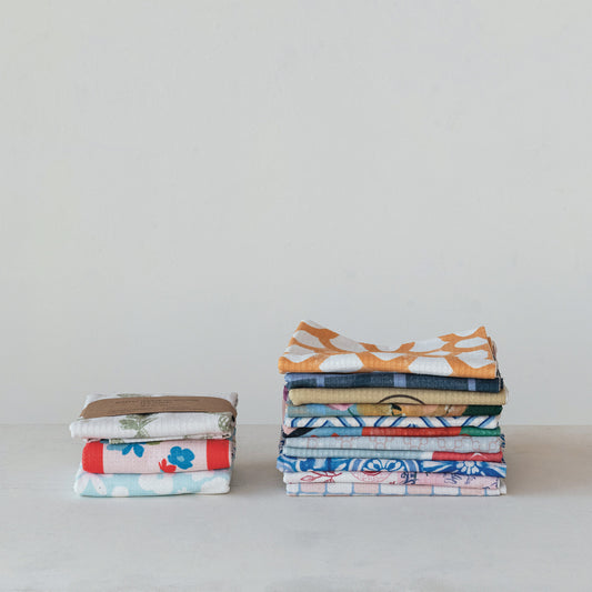 Eco-friendly, absorbent printed microfiber tea towels; available in multiple sizes and colorful designs, neatly folded.