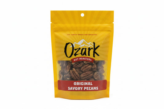 Yellow bag of Savory Pecans from Ozark Nut Roasters with a clear window showing the pecans, mountain graphics, and family owned note. Sizes available.