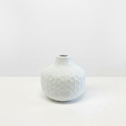 Small round white ceramic vase with hand-carved details and narrow opening; available sizes: small.