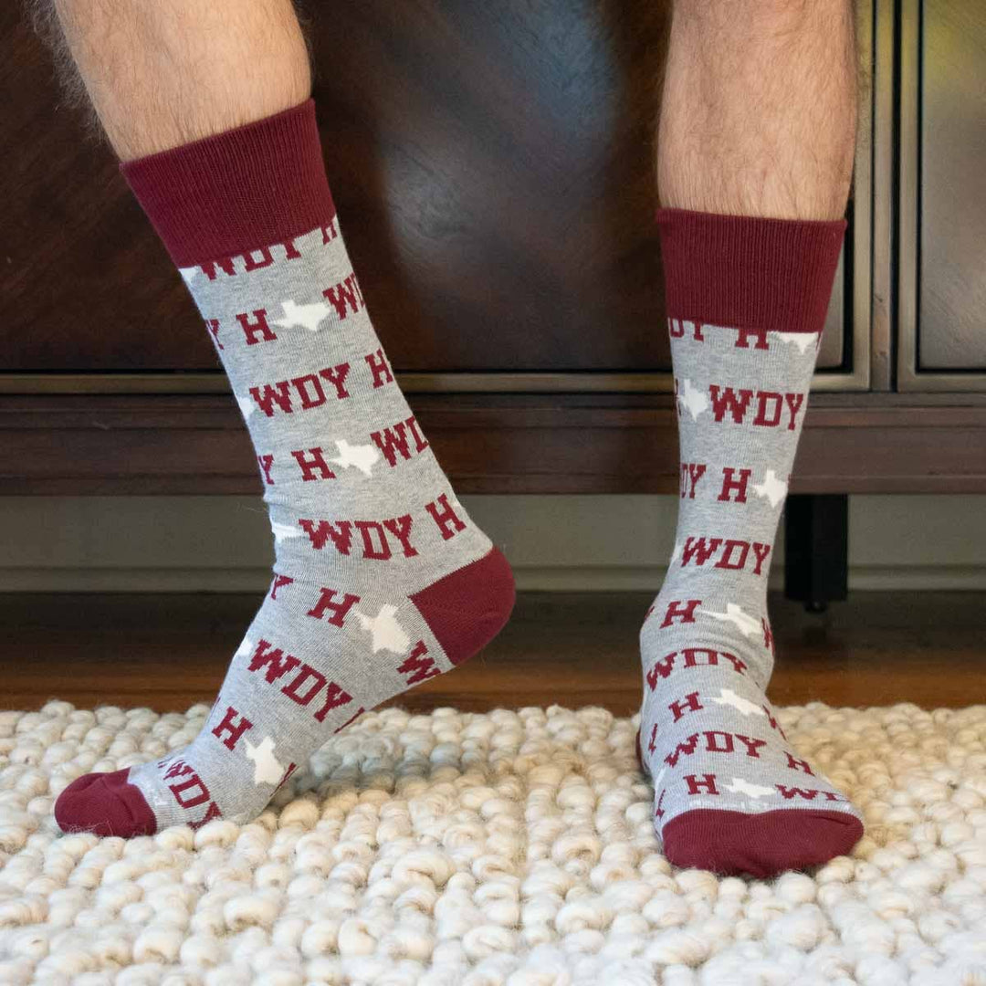 Men’s Howdy Socks in multiple sizes shown. White with bold lettering and stripes, designed for team spirit. Sizes: S-XL.
