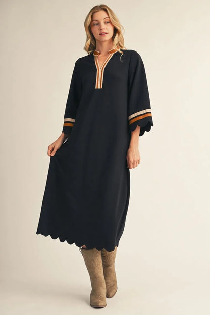 Black Solid Midi Dress With Scalloped Edges, featuring gold and white trim on the collar and cuffs, relaxed silhouette, scalloped hem and sleeves. Available in sizes XS–XL.