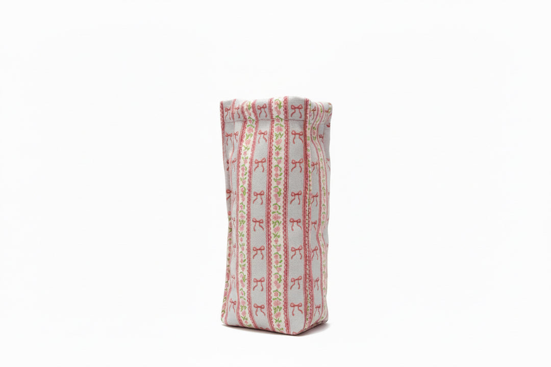 Rectangular, upright pouch with red bow and green dot stripes on white. Available sizes: small, medium, large.
