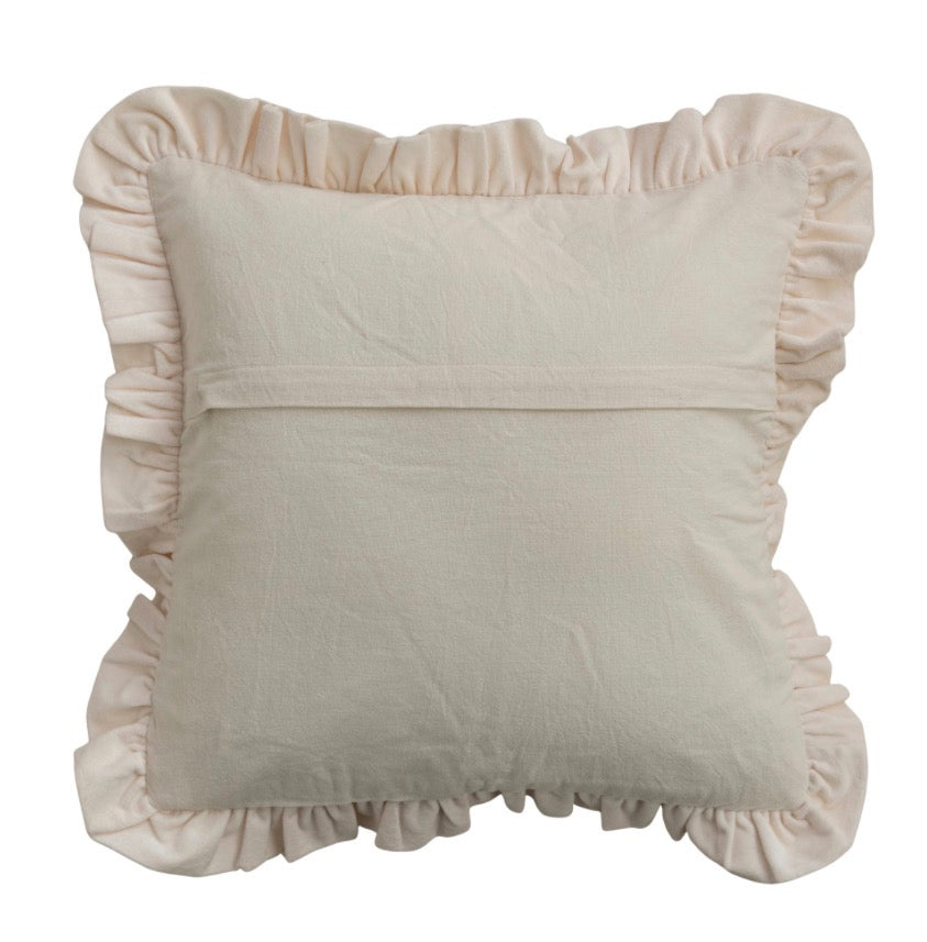 Square beige throw pillow with scalloped embroidered bow, ruffle border, and envelope-style back closure. Available sizes: 18″x18″, 20″x20″.