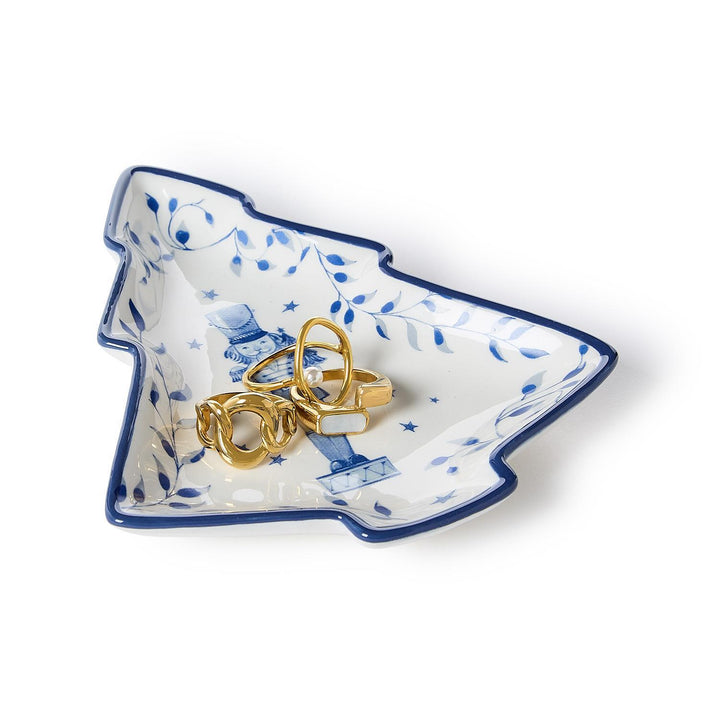 A Season’s Gala Christmas tree-shaped tidbit dish with blue botanical patterns and a nutcracker motif.