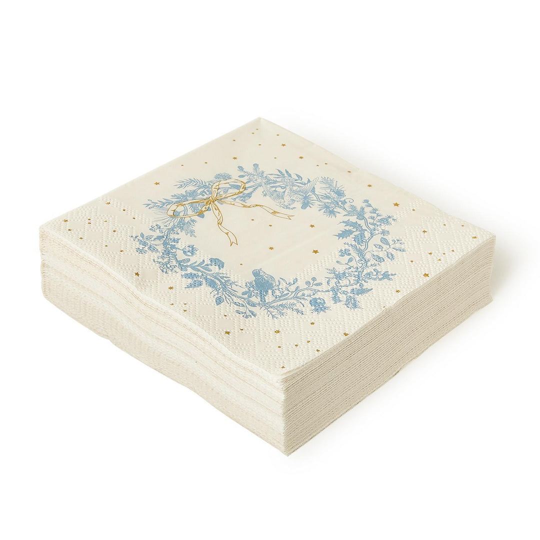 Square Gilded Cottage paper cocktail napkins featuring a blue botanical wreath pattern with gold accents and a gold ribbon.