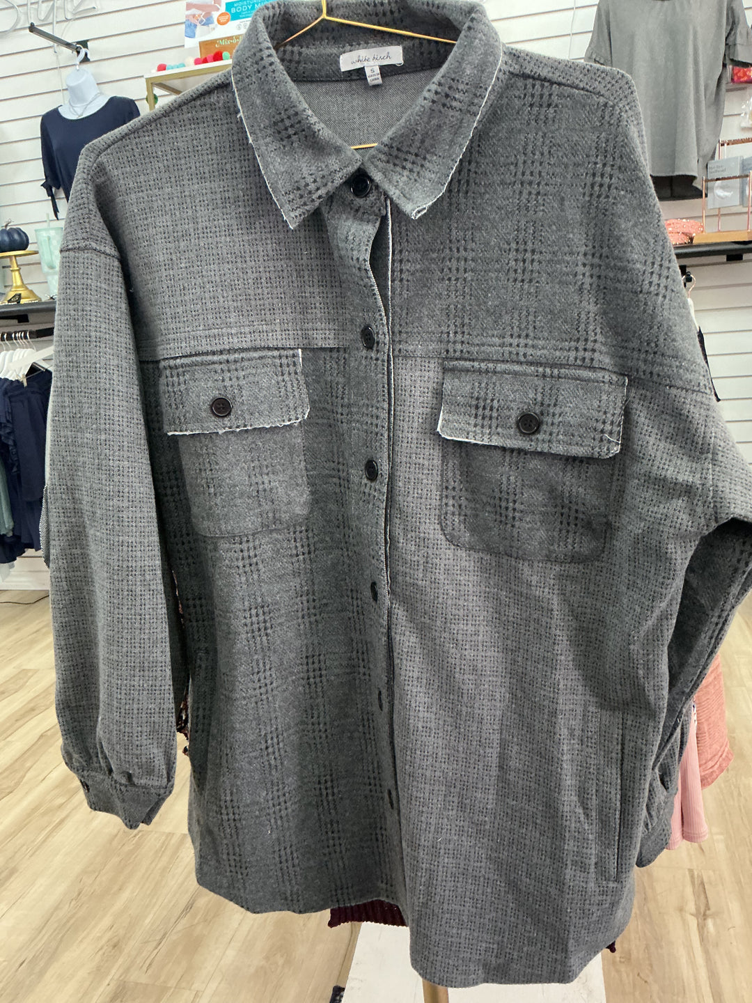 Dark grey plaid button-up jacket with black buttons, long sleeves, two chest pockets. Available in sizes S, M, L, XL.