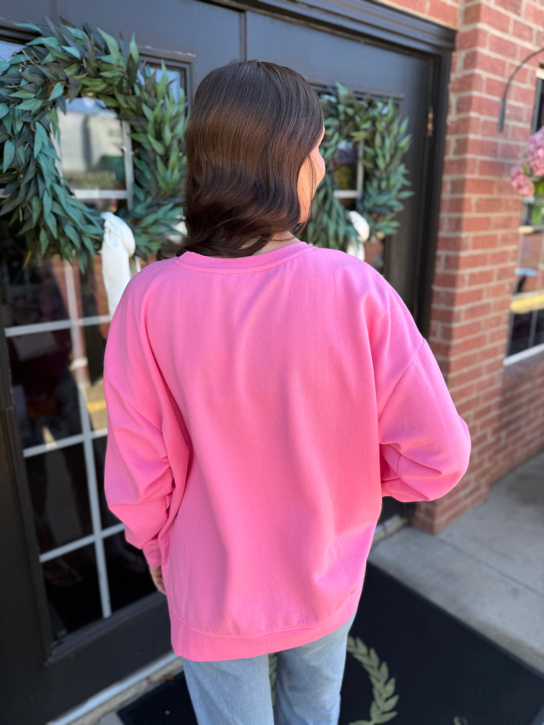Bright pink long-sleeved sequin bow sweatshirt in a relaxed fit.