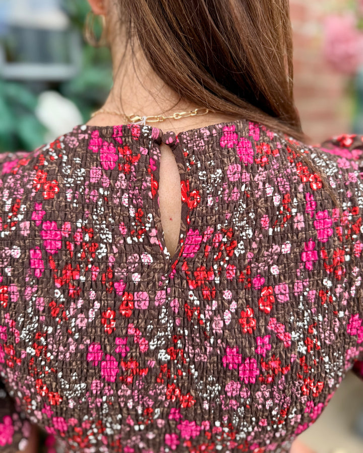 Cocoa brown Lucille Granada Glen Cocoa Dress with red and pink floral patterns, small teardrop keyhole at neckline; available in sizes XS–XL.