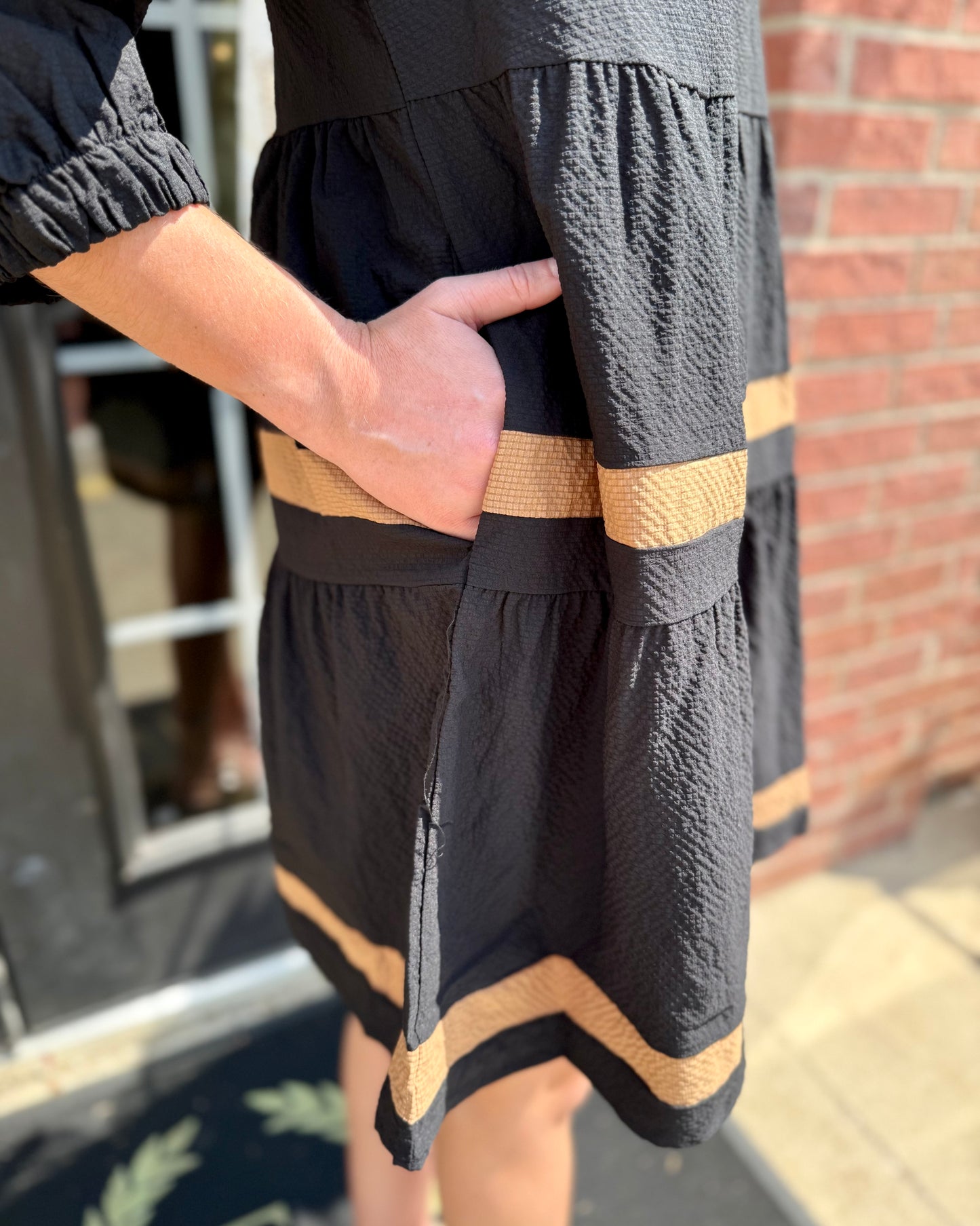 Cooper Dress | Black + Tan—black fabric with tan stripes, V-neckline, side pockets. Available in sizes XS–XL.