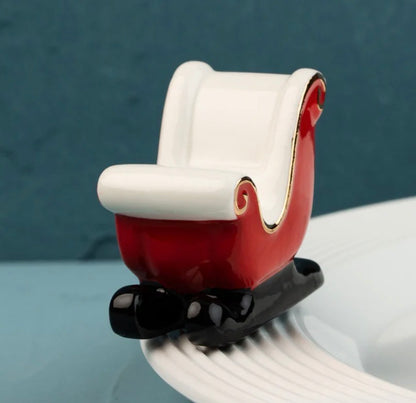 Red ceramic sleigh figurine with white trim and gold accents. Available in mini size.