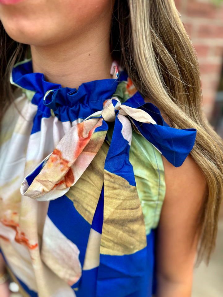 Royal Blue Floral Ruffle Tie-Neck Sleeveless Dress. Available in sizes XS–XL.