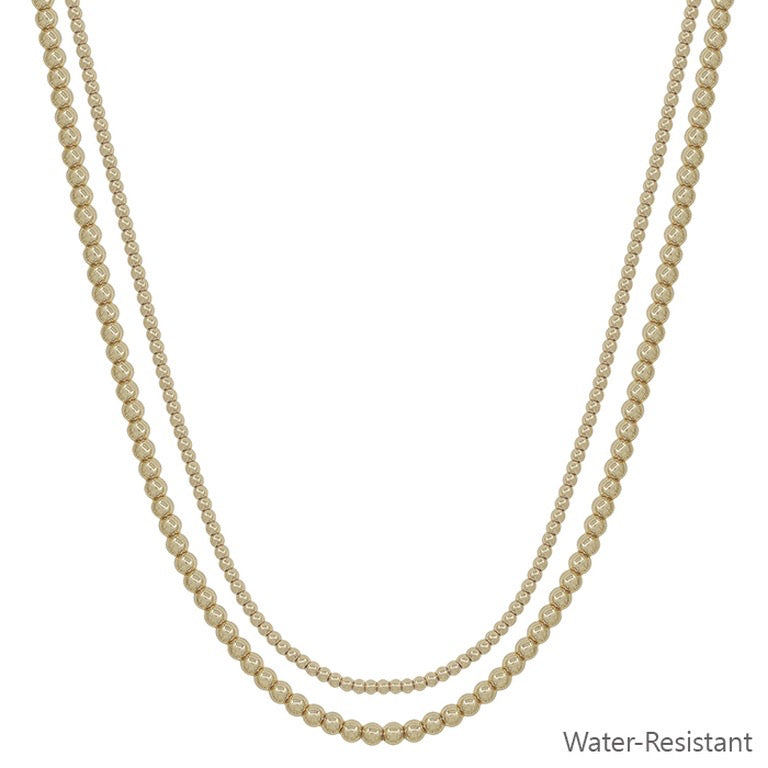 The Fan Gold Silver Necklace has double layers of round, gold-toned beads in varying sizes. Available sizes: 16", 18". Water-resistant.