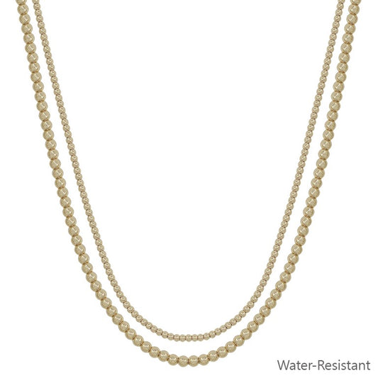 The Fan Gold Silver Necklace has double layers of round, gold-toned beads in varying sizes. Available sizes: 16", 18". Water-resistant.