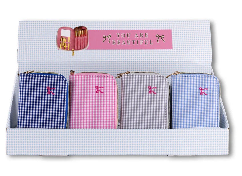 Four zippered gingham pouches in blue, pink, gray, and light pink. Travel size.