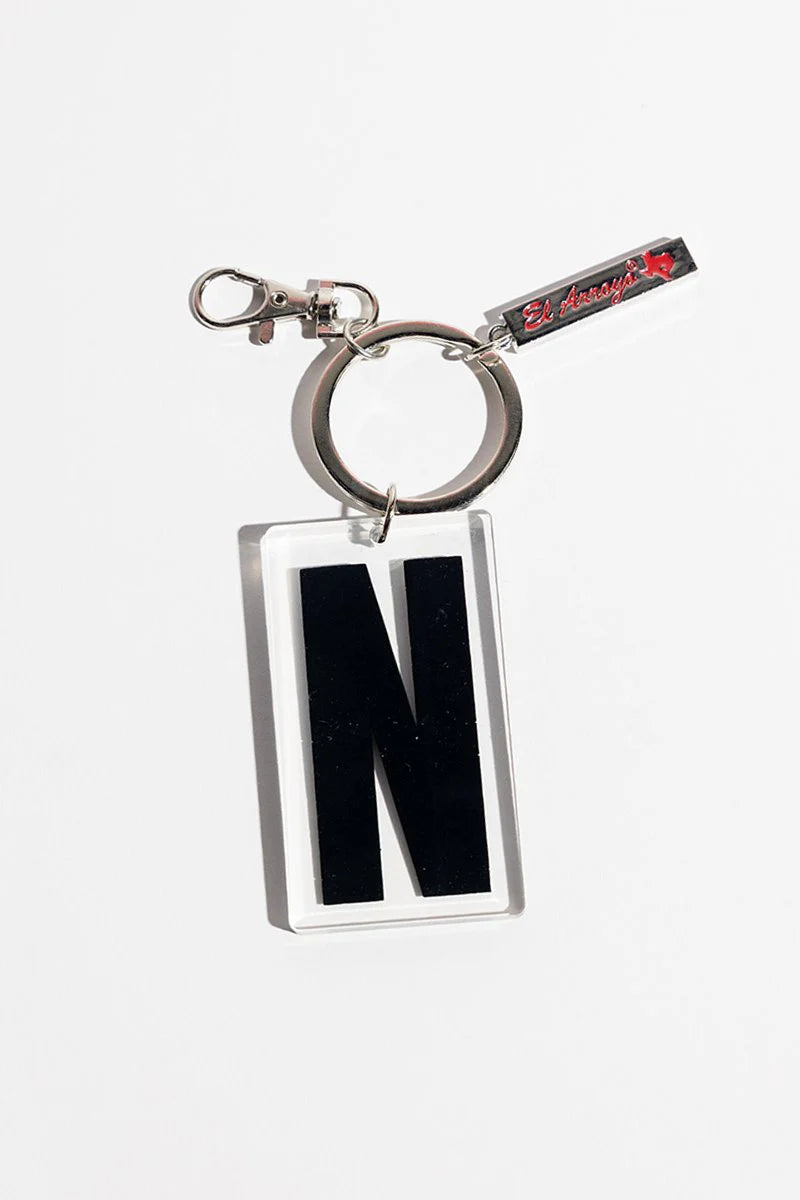 Clear acrylic keychain with bold black "N," metal ring, small red-tag accent. Size: 2"x1.5".