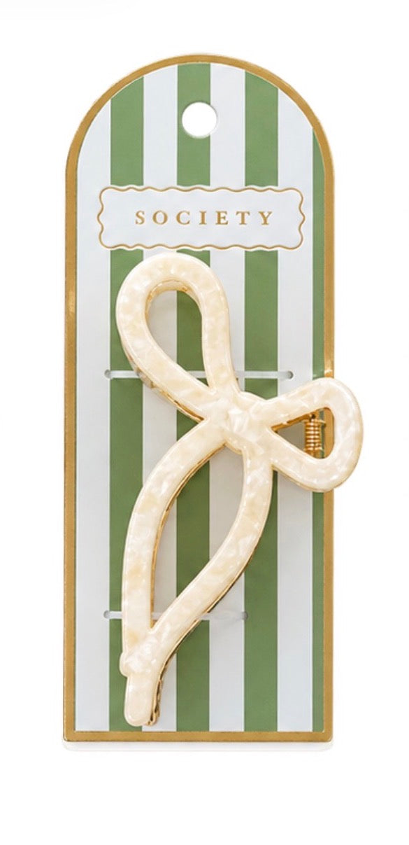 Cream-colored, metal bow claw clip with marbled pattern; available sizes not specified.
