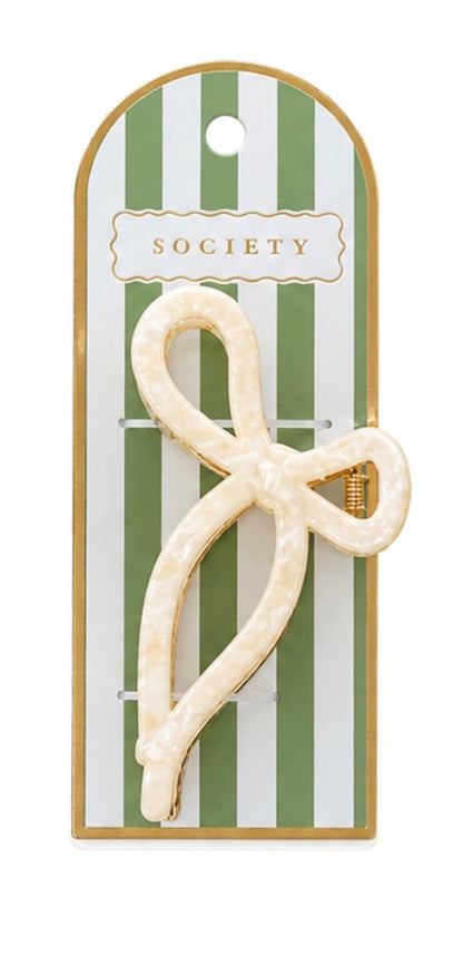 Cream-colored, metal bow claw clip with marbled pattern; available sizes not specified.