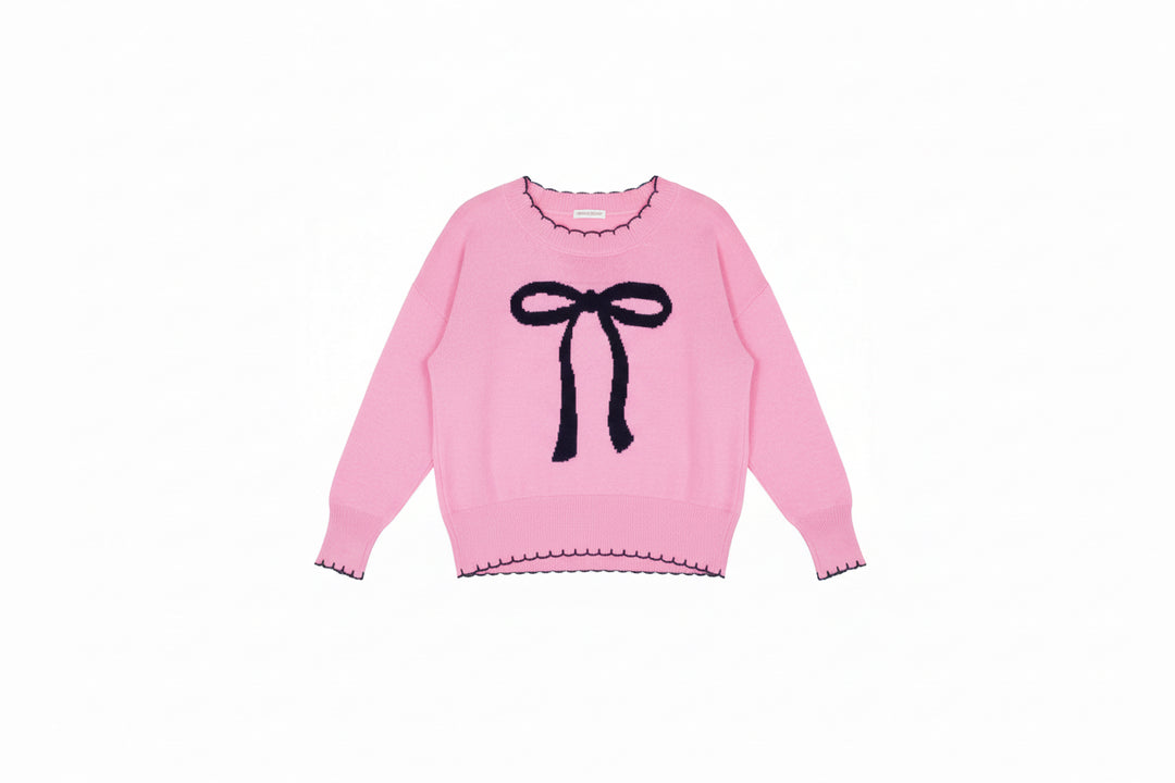 Light pink long sleeve sweater with black bow and scalloped trim; available in sizes XS-XL.