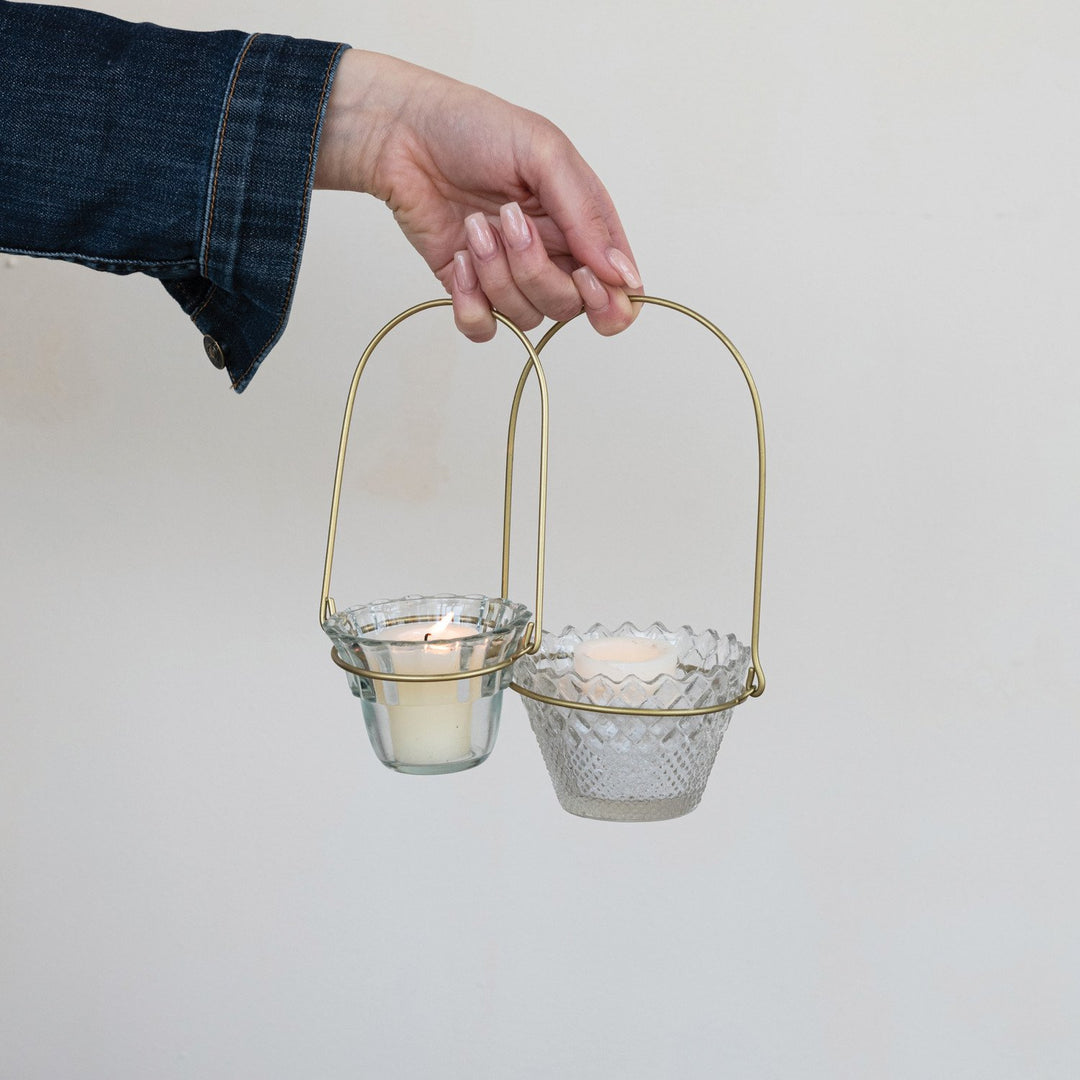 Antique brass wire handle with two Hanging Pressed Glass Votive Holders, each holding a lit candle. Sizes: Small, Large.