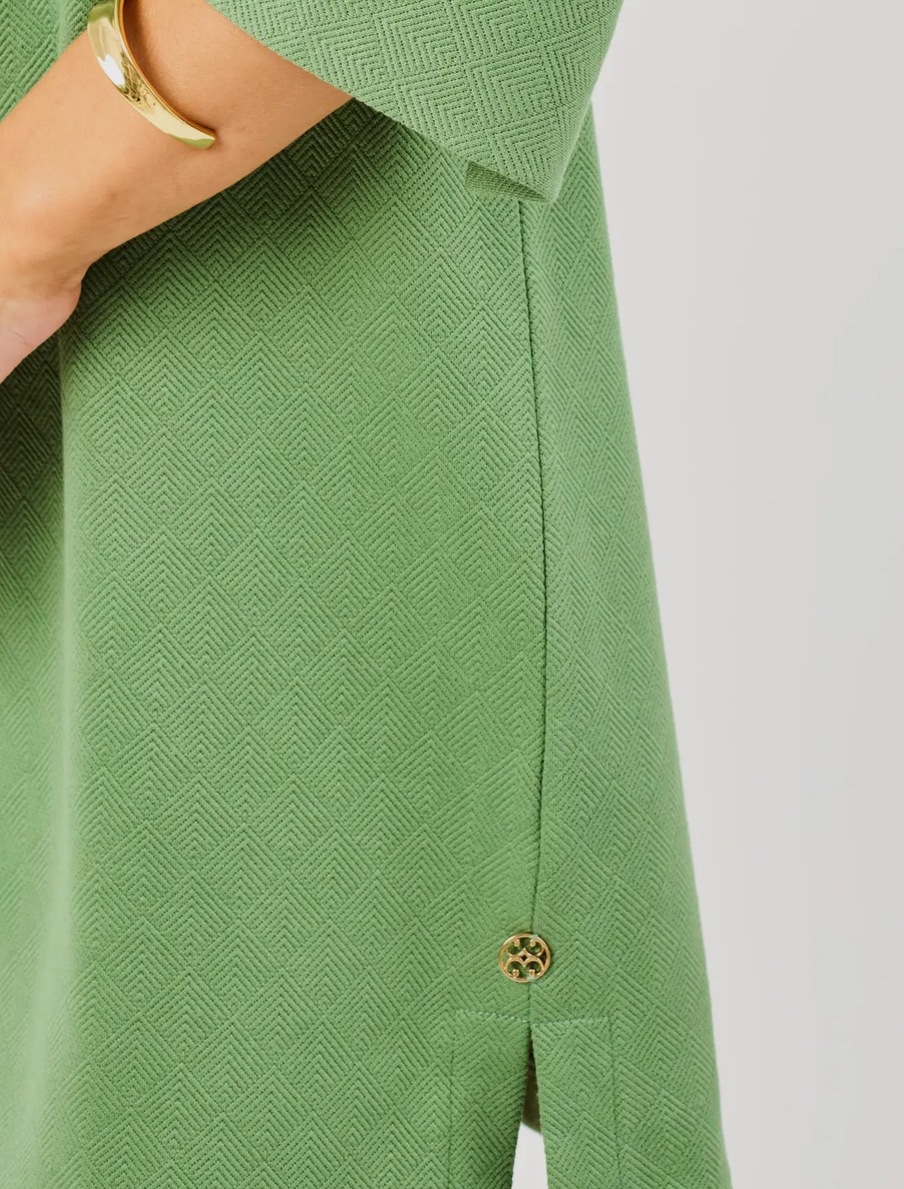 Hadley Green Dress in textured green fabric with geometric pattern, side slit, gold hem button. Available in XS-XL.