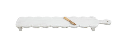 Long, white mango wood cheese board with scalloped edges, short legs. Includes small wooden spreader. Size: Long.