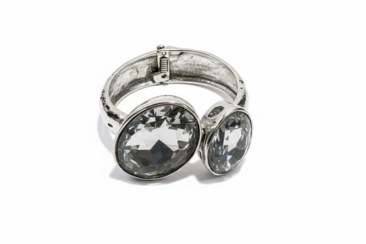Hinged Silver Stone Bangle with two large oval clear gemstones on a silver band; available in S, M, and L sizes.