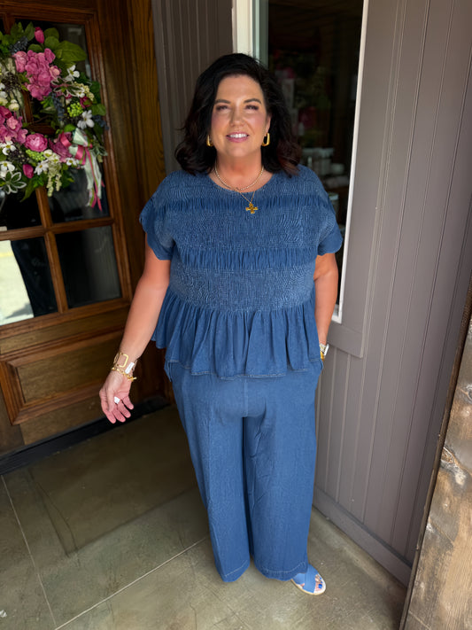 Blaire Chambray Smocked Peplum Top featuring scalloped ruffle sleeves and a smocked bodice; available in sizes XS–XL.