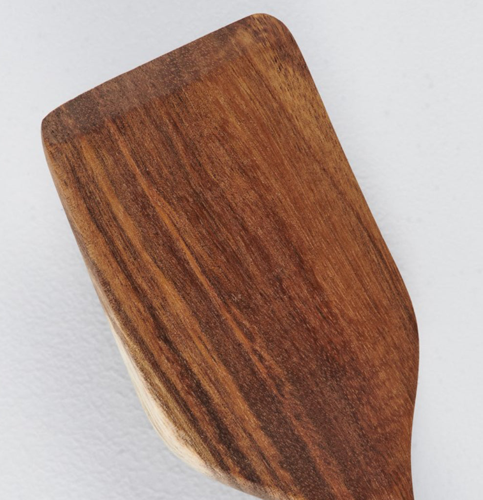 Close-up of wooden spatula with rounded edges and visible grain; available in 10-inch and 12-inch sizes.