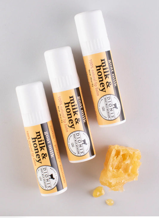 Goat Milk Lip Balm in three tubes. Packaging: white and beige with black logo. Ensures soft, hydrated lips. Available sizes: single 5g tube, pack of three 5g tubes.