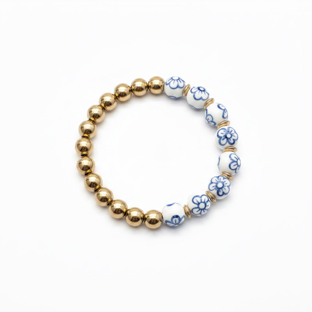 Alternating gold and white beads with blue floral designs form the Chinoiserie Pearl Stretch Bracelet. Available in multiple sizes.