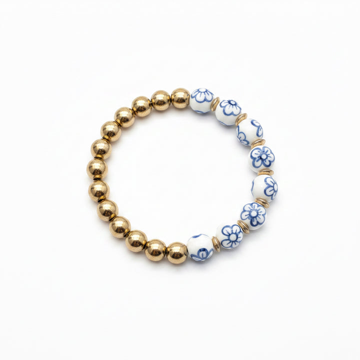 Alternating gold and white beads with blue floral designs form the Chinoiserie Pearl Stretch Bracelet. Available in multiple sizes.