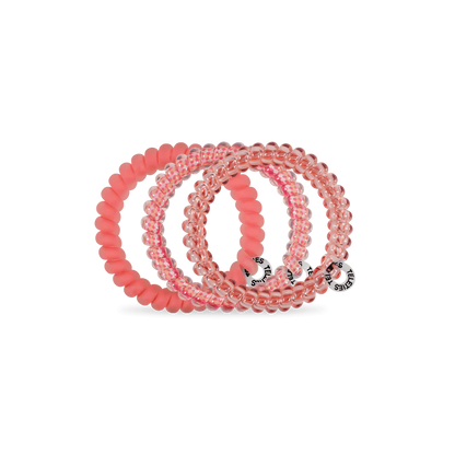 Three TELETIES Hair Ties in clear pink and solid pink, spiral-shaped with logo tags. Available in small and large sizes.