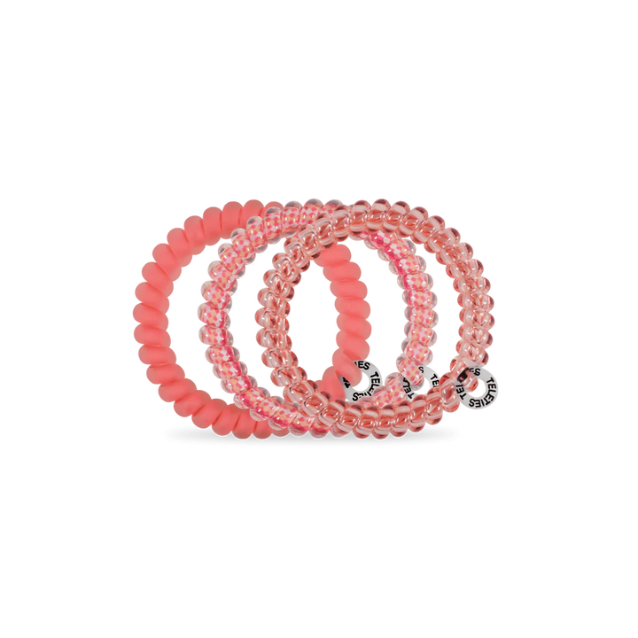 Three TELETIES Hair Ties in clear pink and solid pink, spiral-shaped with logo tags. Available in small and large sizes.