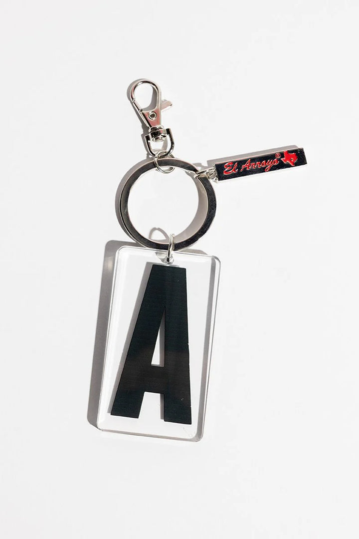 Clear acrylic keychain with bold black "A," silver ring, clasp, and small black tag. Available in standard size only.