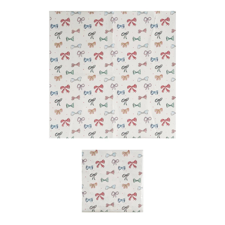 Square 6-1/2” paper napkins with red, green, and black bow pattern; available in 6-1/2” size.
