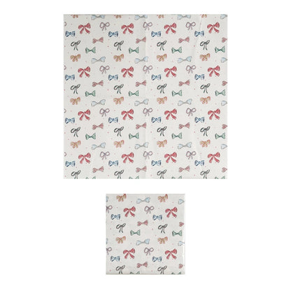 Square 6-1/2” paper napkins with red, green, and black bow pattern; available in 6-1/2” size.
