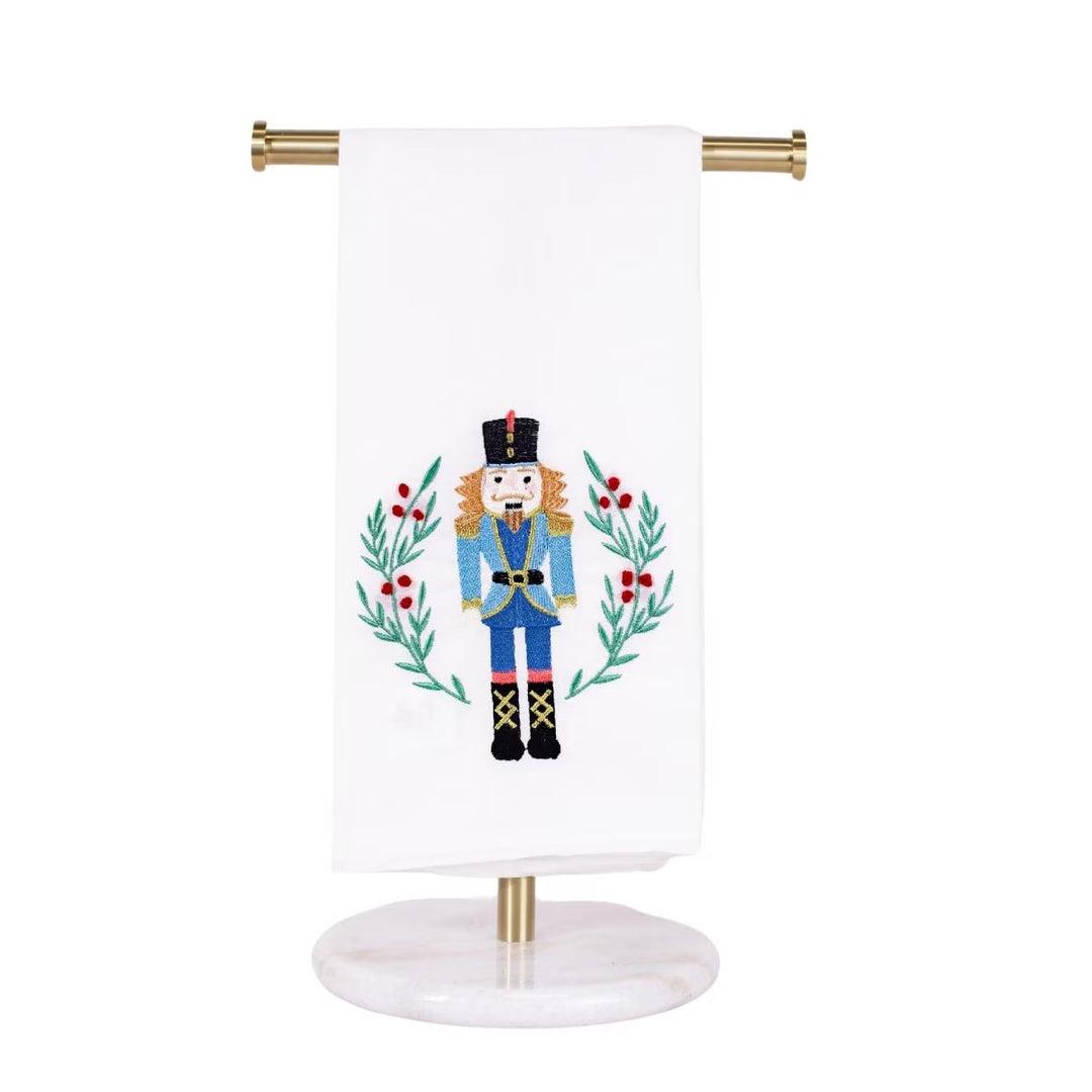 Fulmer Nutcracker hand towel with embroidered nutcracker, leafy green wreath, and red berries.