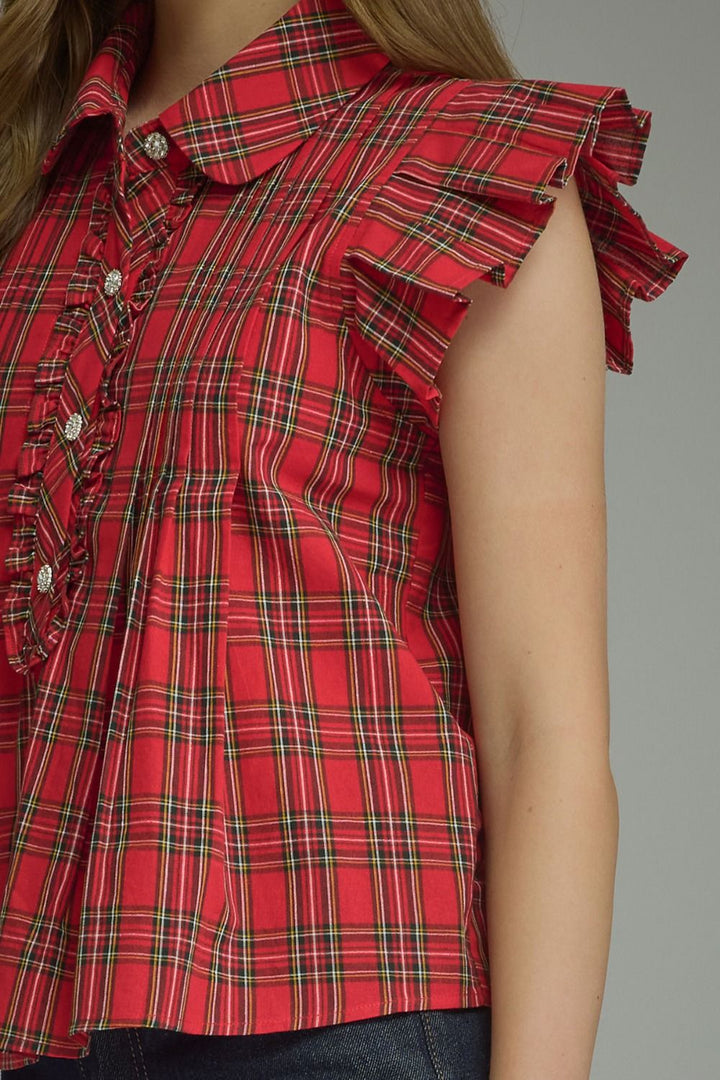 Plaid Ruffle Blouse with decorative buttons and ruffled shoulders; available in sizes XS-XL.