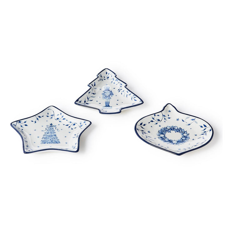 Three Season’s Gala Tidbit dishes in white ceramic with blue rims, featuring illustrations of a Christmas tree, a nutcracker, and a holiday wreath.