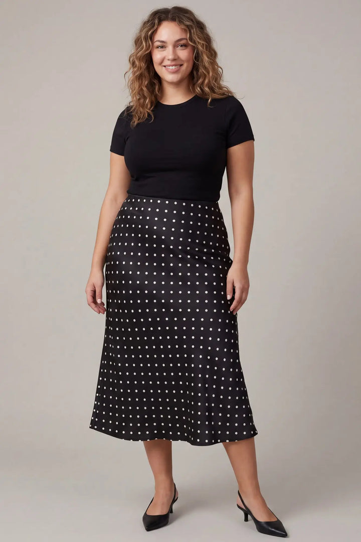 Black woven midi skirt with white polka dots. Available in various sizes.